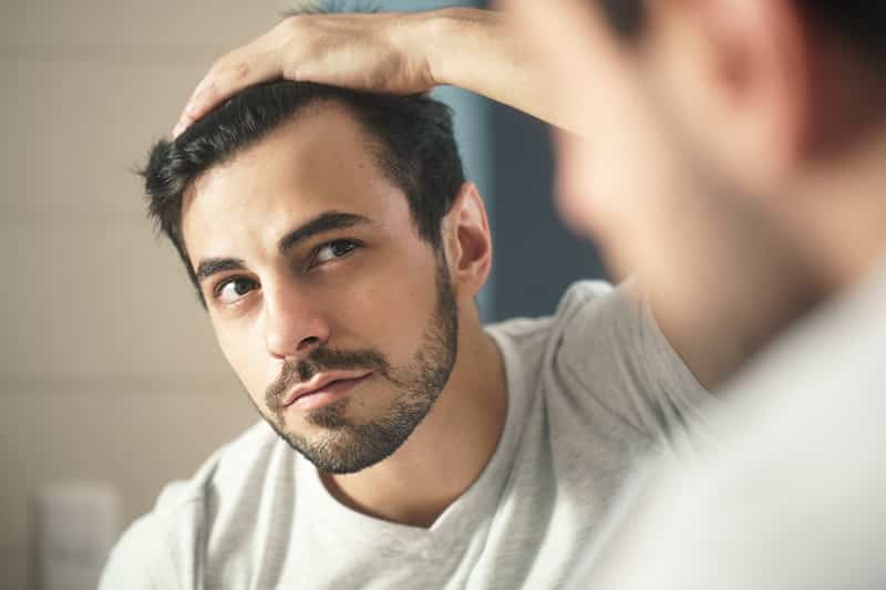 Man looking at reflection in mirror